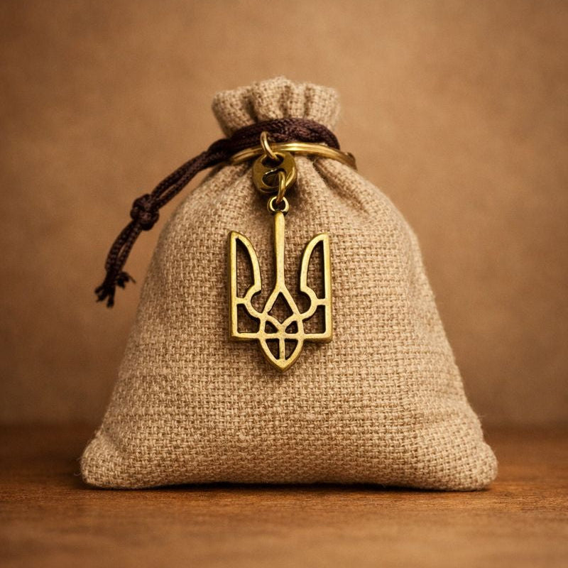 Hessian bag with a gold trident pendant on a brown background